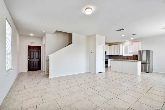 a kitchen with white cabinets and refrigerator