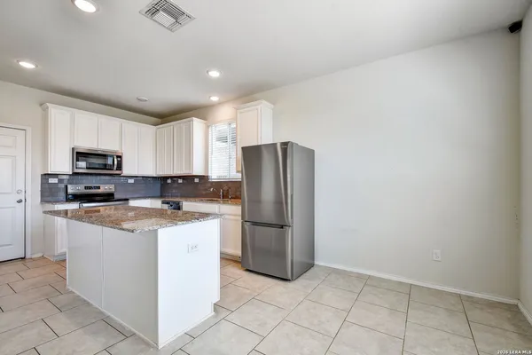 a kitchen with stainless steel appliances granite countertop a refrigerator sink and stove