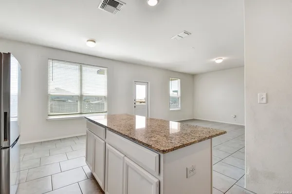 a kitchen with granite countertop a sink and white cabinets