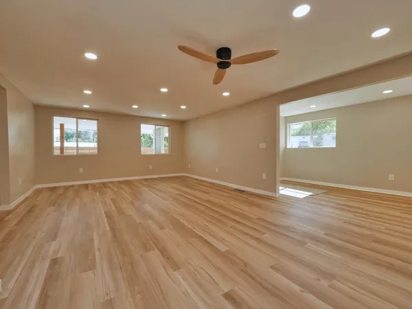 an empty room with wooden floor and a window