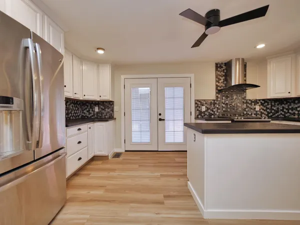 a kitchen with white cabinets and black appliances