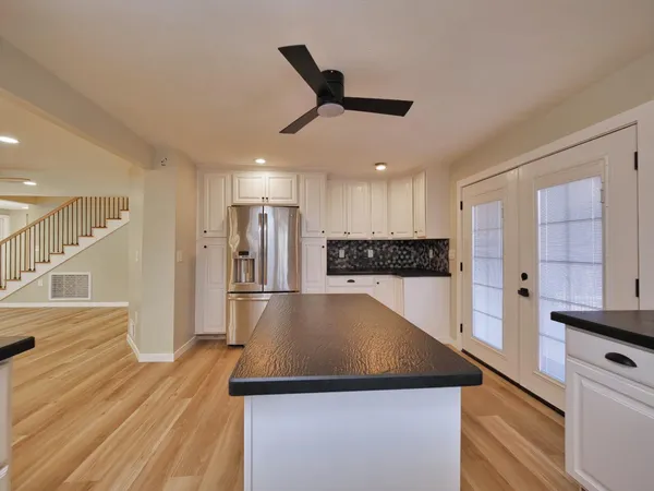 a kitchen with stainless steel appliances granite countertop a sink dishwasher and a stove with wooden floor