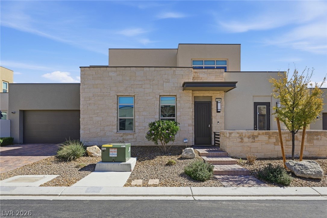 4246 Swift Street Las Vegas, NV 89135 - Photo 2 of 71 Contemporary house with stone siding, stucco siding, driveway, and a garage