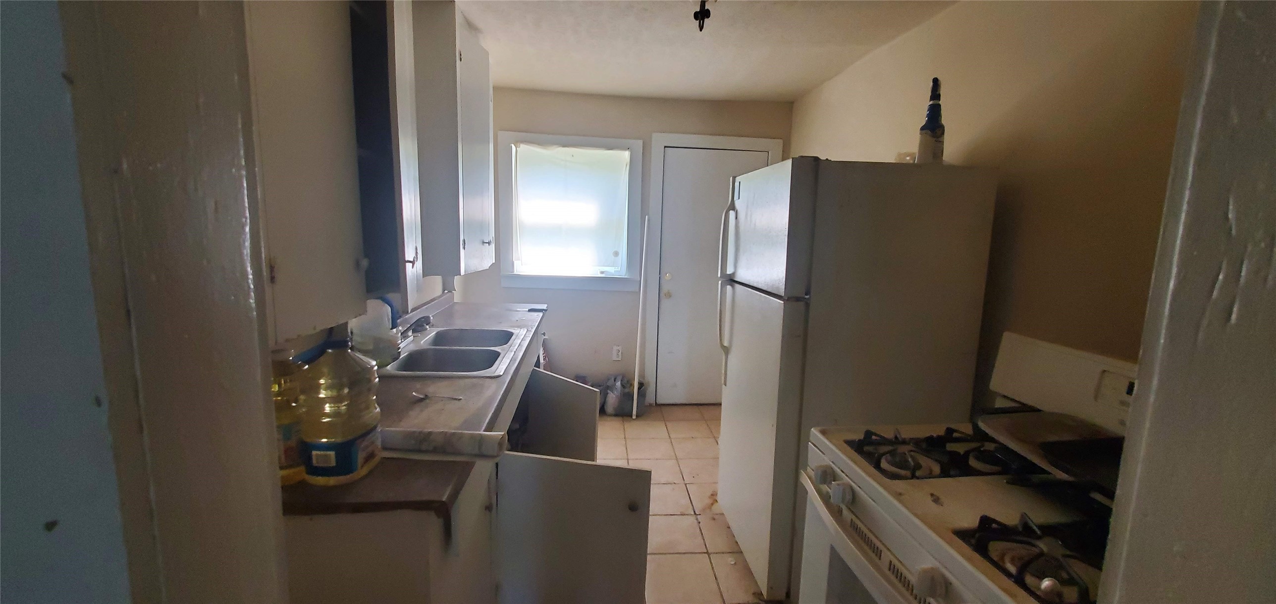 7328 Parkes Street Houston, TX 77088 - Photo 7 of 12 a kitchen with a refrigerator and a stove top oven