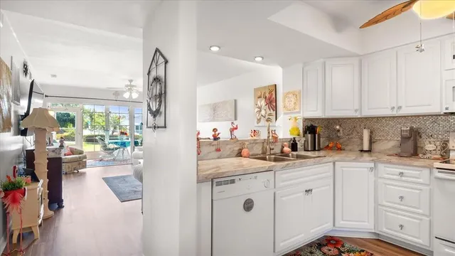a kitchen with white cabinets and sink