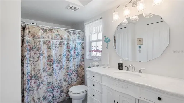a bathroom with a granite countertop sink a toilet and a mirror