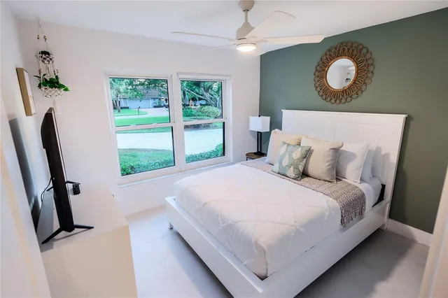 a bedroom with a bed mirror and window