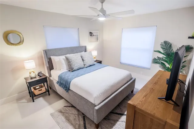 a bedroom with bed and a potted plant