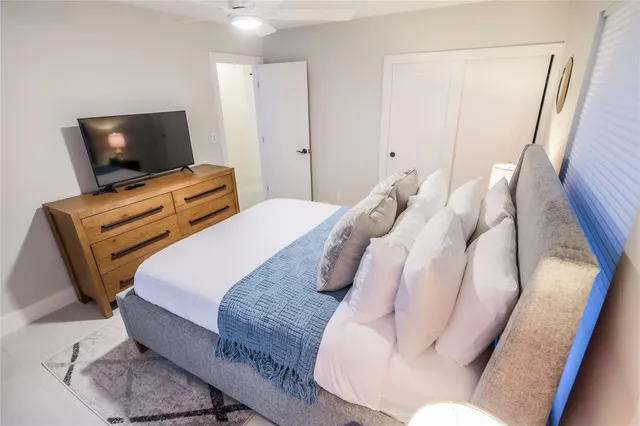 a bedroom with bed and a flat screen tv