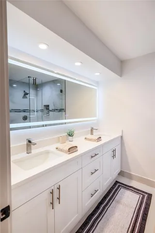 a spacious bathroom with a double vanity sink and mirror