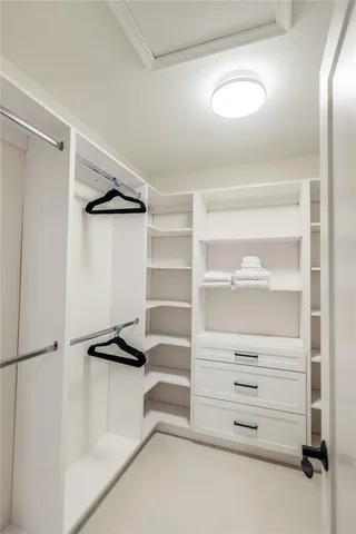 a view of walk in closet with empty racks