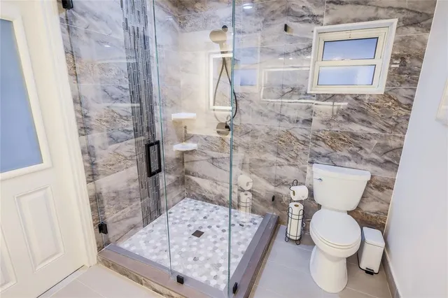 a bathroom with a toilet and a shower