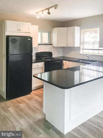a kitchen with granite countertop a refrigerator and a sink