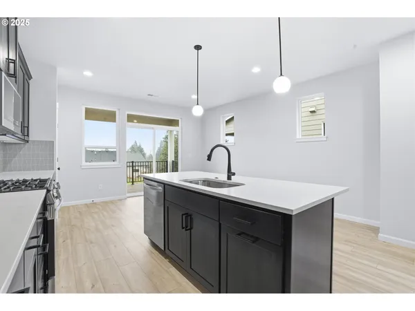 a kitchen with a sink cabinets and wooden floor