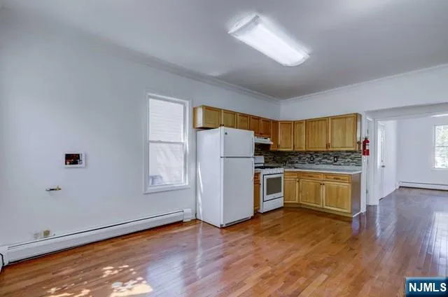a kitchen with granite countertop white cabinets and white appliances
