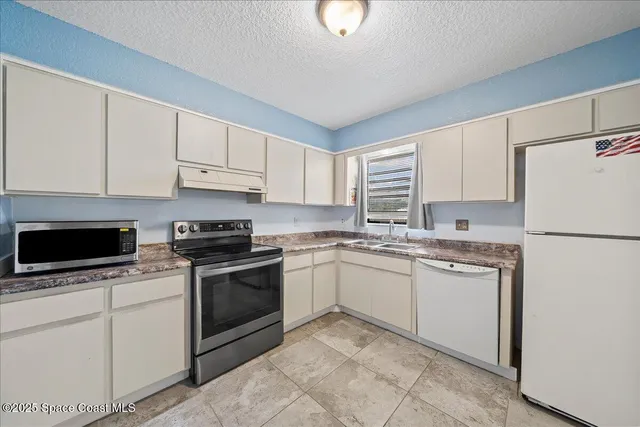 a kitchen with a stove top oven sink and cabinets