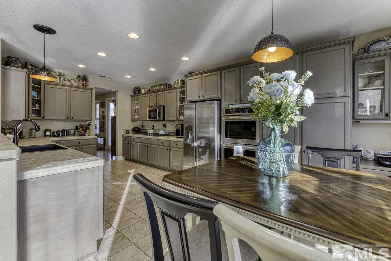 630 Preakness Court Reno, NV 89521 - Photo 6 of 39 a kitchen with kitchen island granite countertop stainless steel appliances a sink a refrigerator a stove and cabinets