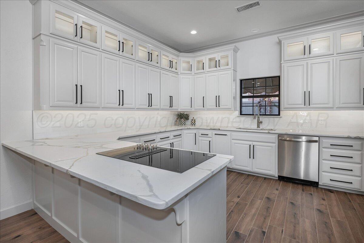 a kitchen with white cabinets a sink and dishwasher