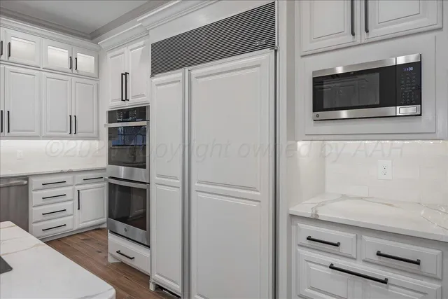 a kitchen with white cabinets and stainless steel appliances