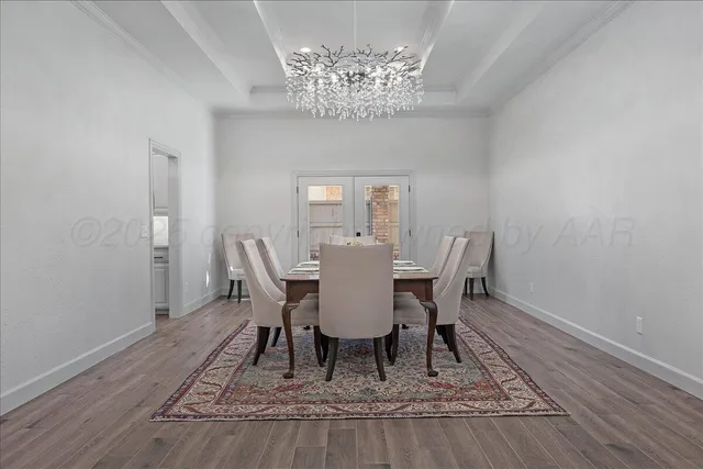 a view of a dining room with furniture a chandelier and wooden floor