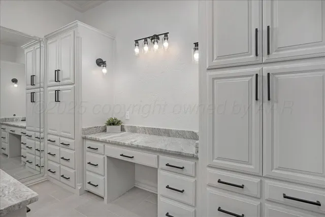a bathroom with a granite countertop sink vanity and mirror