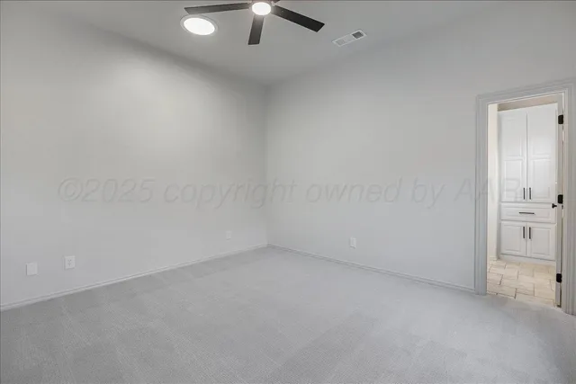 an empty room with a ceiling fan and window
