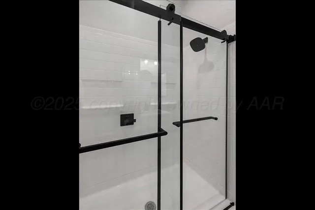 a bathroom with a shower and a mirror