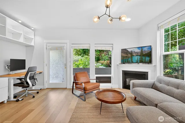 a living room with furniture a fireplace and a floor to ceiling window