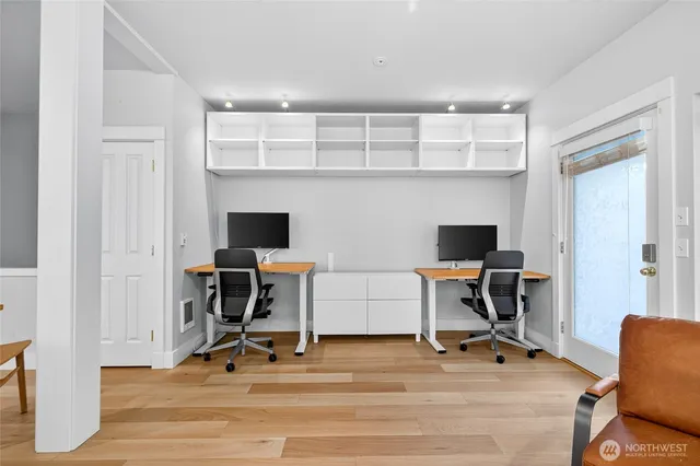 a view of a workspace with furniture and a window
