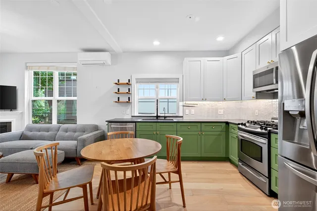 a kitchen with stainless steel appliances granite countertop a stove a refrigerator a table and chairs