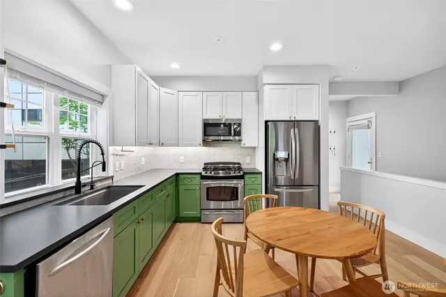 a kitchen with stainless steel appliances granite countertop a kitchen island hardwood floor sink stove and refrigerator