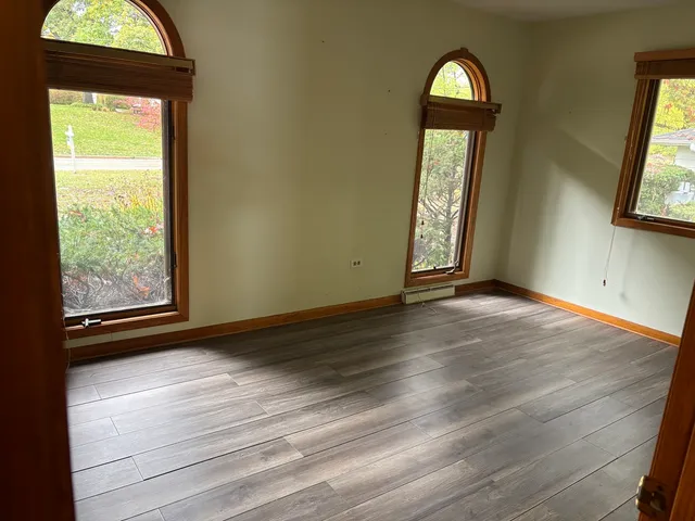an empty room with wooden floor and a window