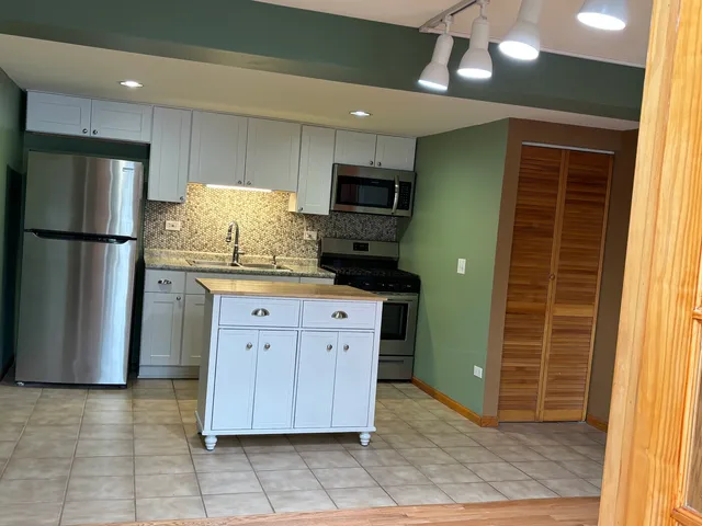 a kitchen with stainless steel appliances a refrigerator and a stove