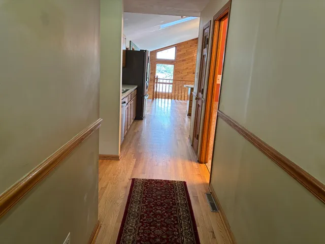 a view of hallway with wooden floor and stairs