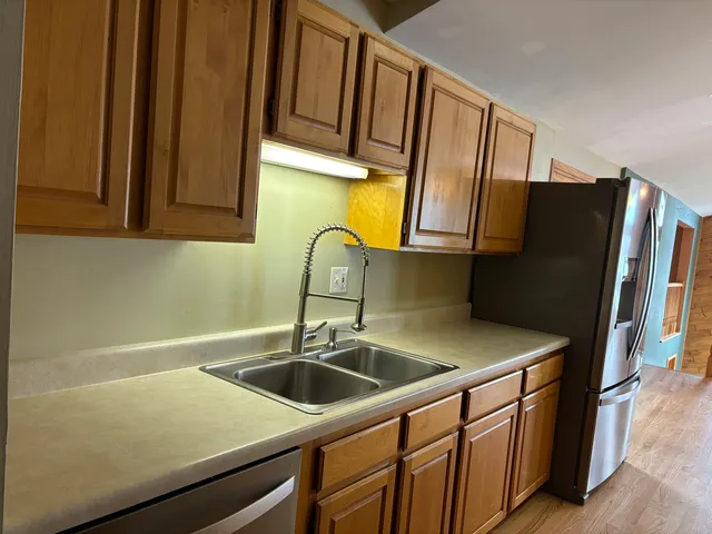 a kitchen with stainless steel appliances a sink cabinets and a refrigerator