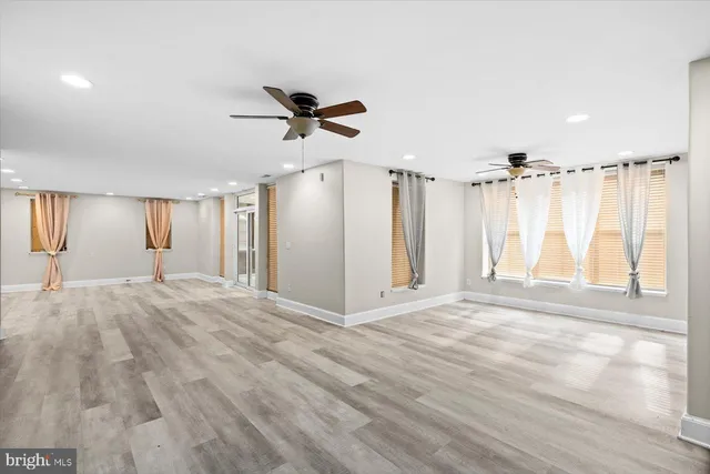 a view of empty room with wooden floor and window