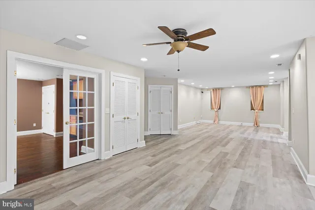 an empty room with wooden floor and cabinets