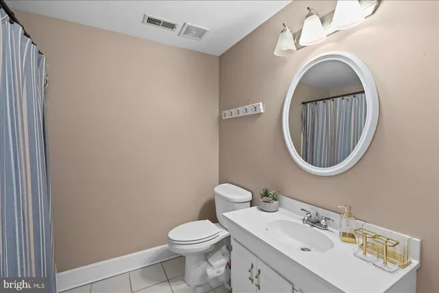 a bedroom with a bed table closet and two windows