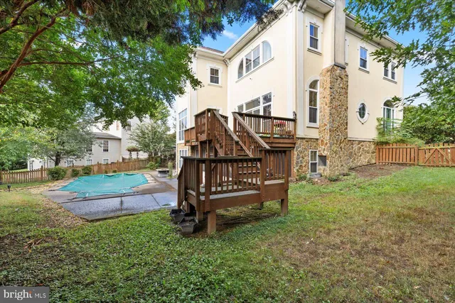 a view of a backyard with large trees and wooden fence