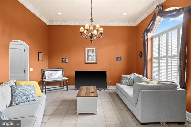 a living room with furniture chandelier and a window