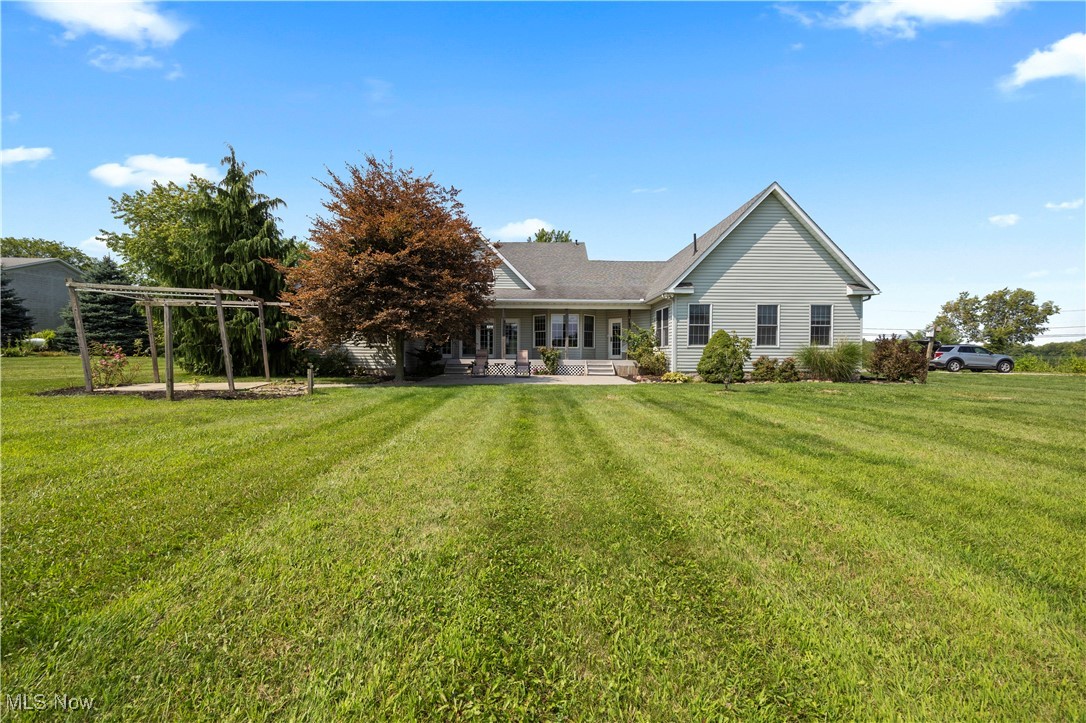 Rear view of property with a yard and a patio