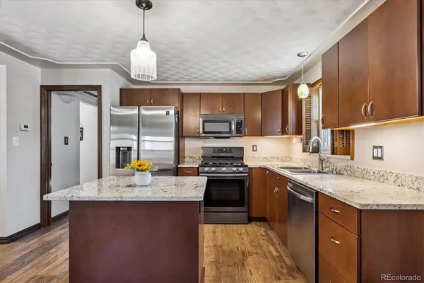 a kitchen with stainless steel appliances granite countertop a sink stove and refrigerator