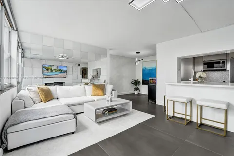 a living room with furniture and view of kitchen