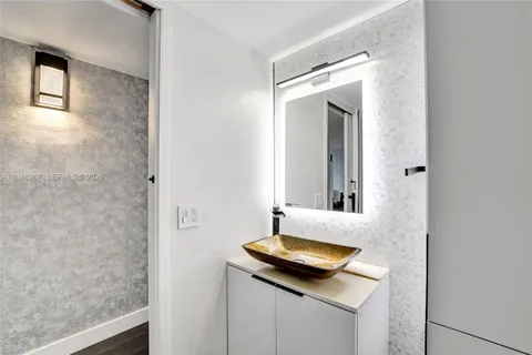 a bathroom with a granite countertop sink and a mirror