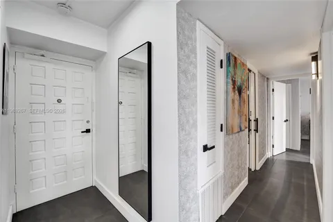 a view of a hallway with wooden floor and closet area