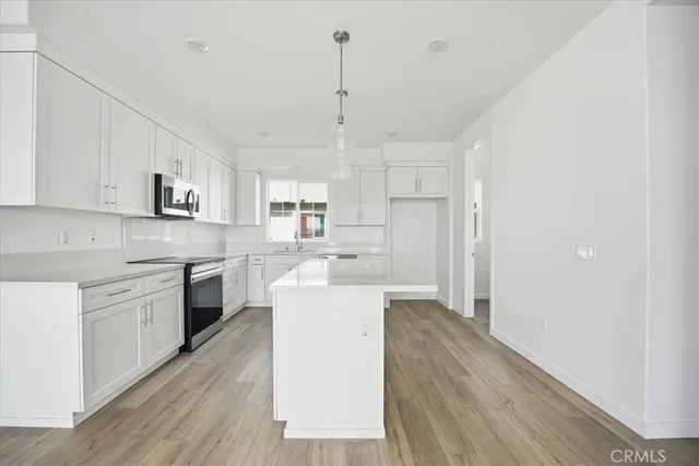 a view of a room that has wooden floor and a window