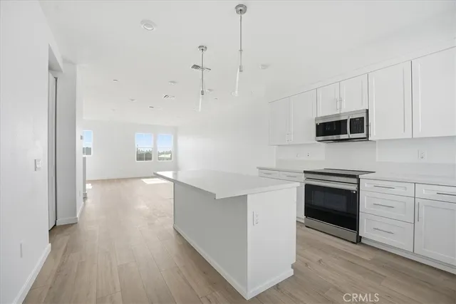 a kitchen with a sink cabinets stainless steel appliances and a window