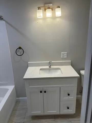 a bathroom with a sink vanity and bathtub