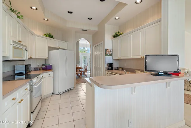a kitchen with stainless steel appliances a sink stove refrigerator and cabinets