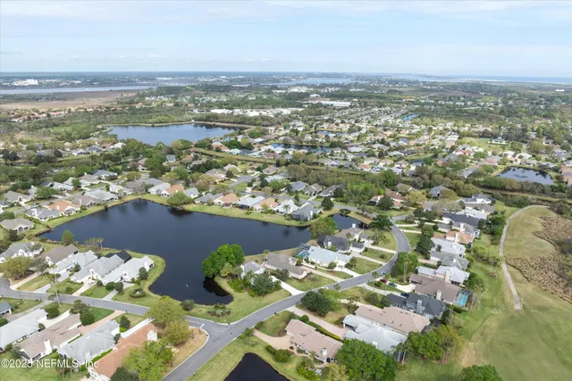 an aerial view of lake and residential houses with outdoor space
